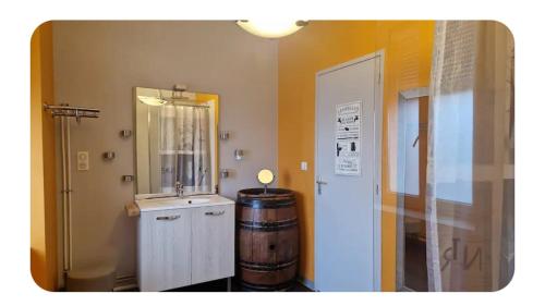 une pièce avec un tonneau de vin et un miroir dans l'établissement Le gîte de La Tête de l'Art, à Objat