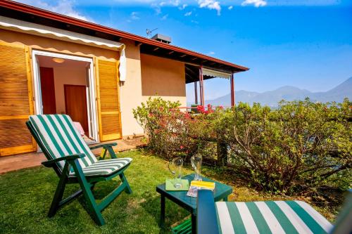 a patio with two chairs and a table and a house at Residenz Roccolo in Ghiffa