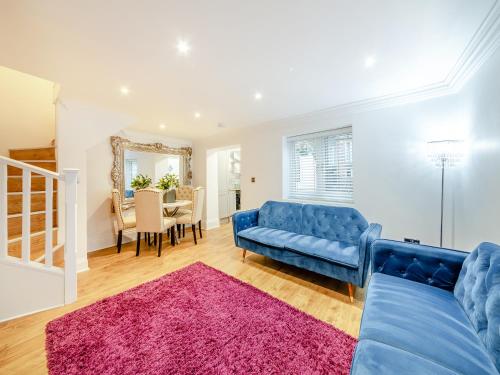 a living room with a blue couch and a pink rug at Violet Cottage - Uk45968 in Yarm