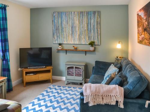 a living room with a couch and a television at Grooms Cottage in Choppington