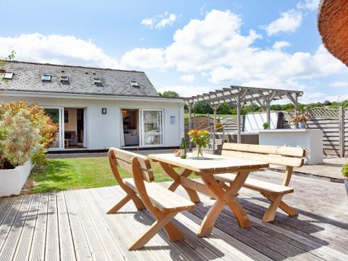 a wooden picnic table and two chairs on a patio at Sundance in Cheriton Bishop