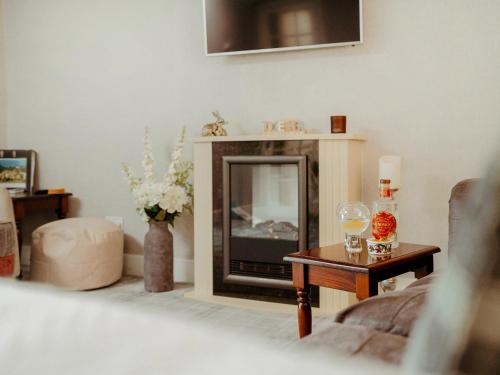 a living room with a tv and a table at Drumwherry By The Sea in Monreith
