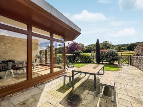 a patio with a table and chairs on a patio at Springfields in North Wootton