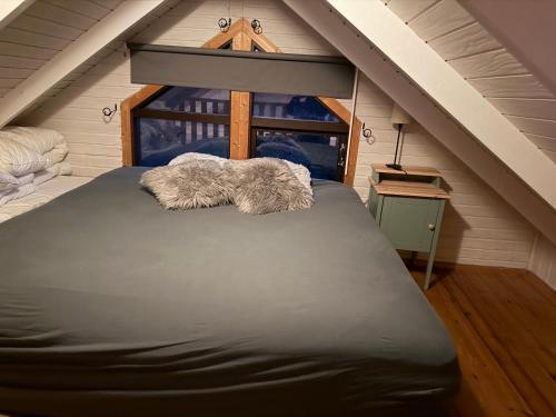 a bedroom with a bed in a attic at Cheerful forest cabin Fireplace and Hot tub in Akranes