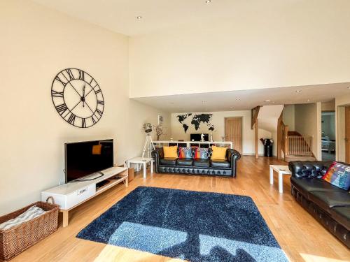a living room with a large clock on the wall at Springfields in North Wootton