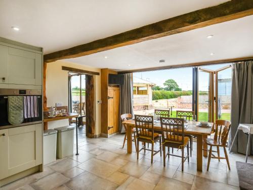 Una cocina y un comedor con mesa y sillas. en Orchard Barn - Uk47458, en Chetton