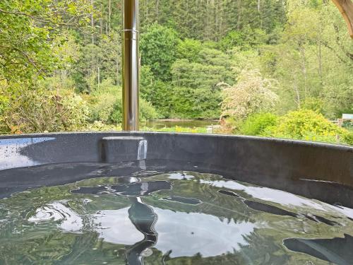 a bath tub filled with water in front of a window at Dunmallet in Pooley Bridge