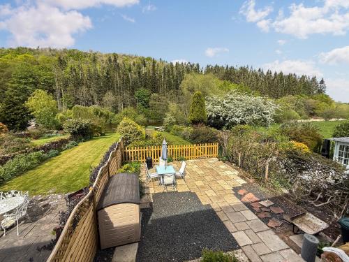 a view of a garden with a bench and an umbrella at Dunmallet in Pooley Bridge