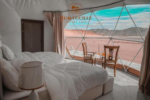 a bedroom with a bed and a view of a beach at RUM LUCILLE lUXURY CAMP in Wadi Rum