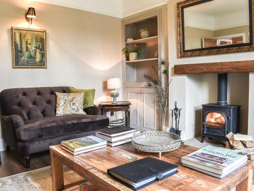 ein Wohnzimmer mit einem Sofa und einem Holzofen in der Unterkunft Honey Cottage in Gargrave