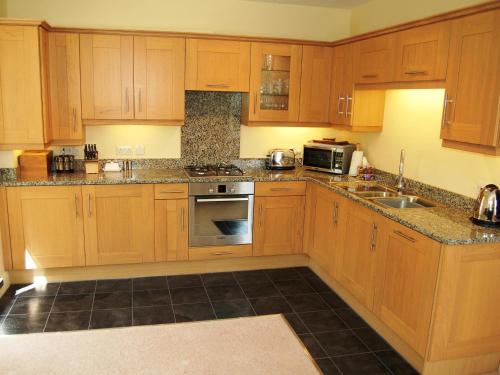 a kitchen with wooden cabinets and a stove top oven at Bishop View in Braithwaite