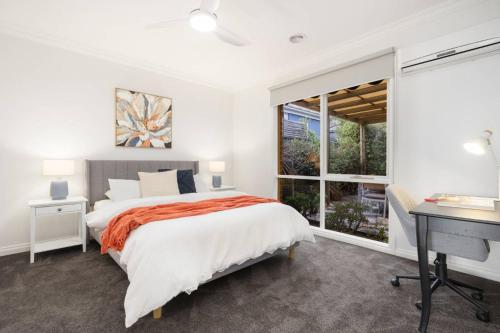 Un dormitorio con una cama y un escritorio y una ventana. en Tranquil Highett House With Storage-2k From Beach!, en Highett