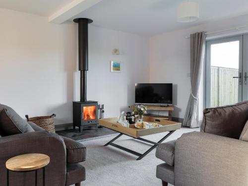 a living room with a fireplace and a tv at The Maddocks - Uk36311 in Whitchurch