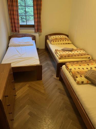 um quarto com três camas e uma janela em Apartmány Pod Javorem em Pec pod Sněžkou