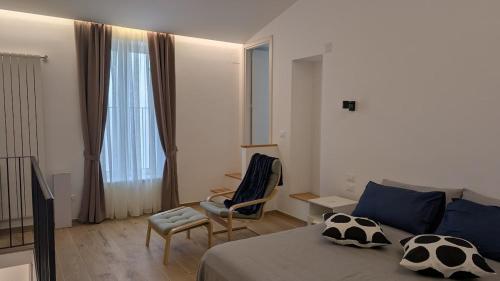 ein Schlafzimmer mit einem Bett und einem Stuhl und einem Fenster in der Unterkunft La casa degli Archibugi in Sulmona
