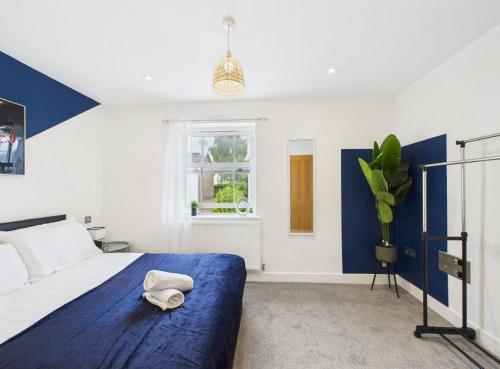 a bedroom with a blue bed with a hat on it at Elegant 3-Bed Near Station, Pantiles & Calverley in Royal Tunbridge Wells