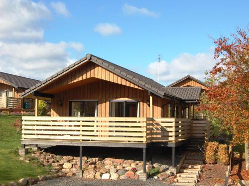 a large wooden house with a porch at Amber Nook in Tirril