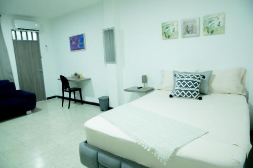 a bedroom with a large white bed and a table at CASA ROOSEVELT in Cali