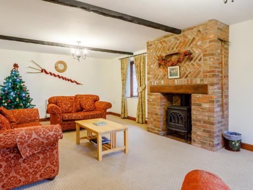 a living room with a fireplace and a christmas tree at Pantiles Barn - E3866 in Runcton Holme