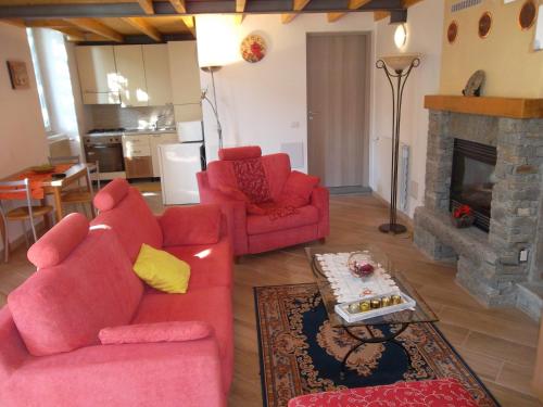 - un salon avec deux canapés rouges et une cheminée dans l'établissement FeWo Luino Loft, à Luino