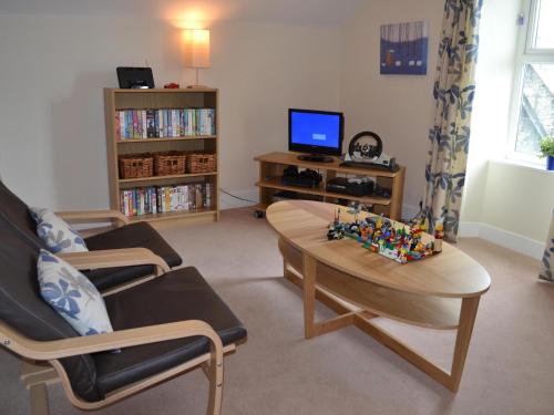 a living room with a coffee table and a tv at Bede's Cottage in Windermere