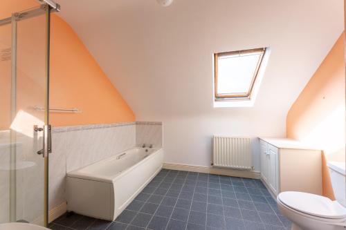 an attic bathroom with a tub and a toilet at Ballyneill Farmhouse in Carrick-on-Suir