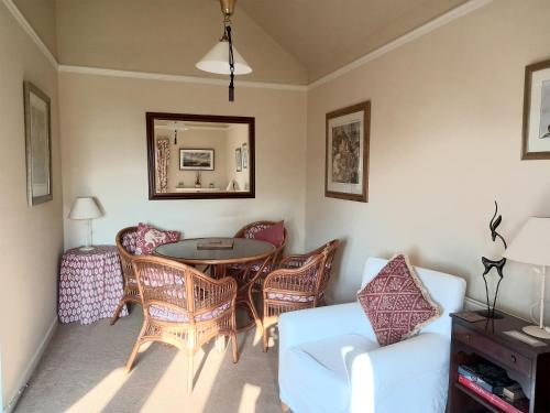 a living room with a table and chairs at Tarandoun Cottage in Helensburgh