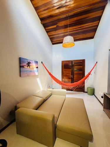 a living room with a couch and a hammock at Chale Pitanga 38 in Pipa