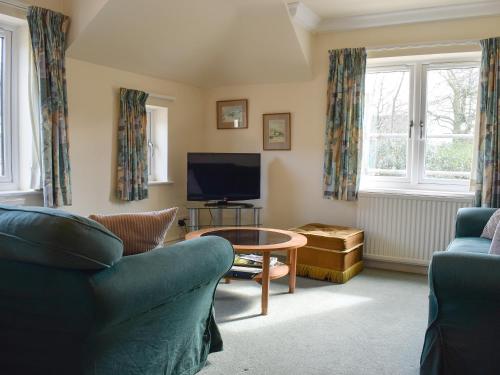 a living room with a couch and a tv at Oaklands in Ambleside