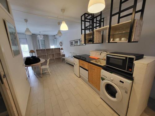 una cucina con lavatrice e asciugatrice di Loft marsa cube vue panoramique vue mer a La Marsa