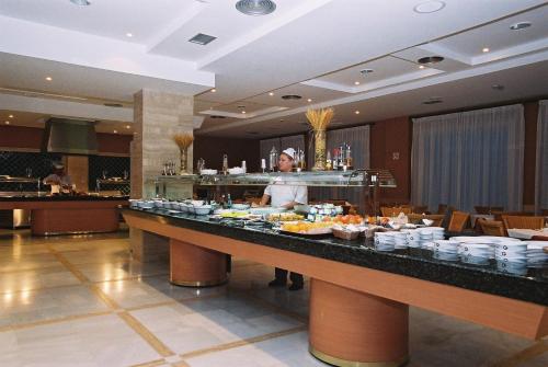 a man standing behind a buffet in a hotel at Arena Center in Roquetas de Mar