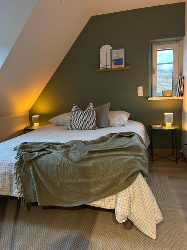 a bedroom with a large bed with a green wall at Charmant appartement avec vue sur les vignes in Ammerschwihr