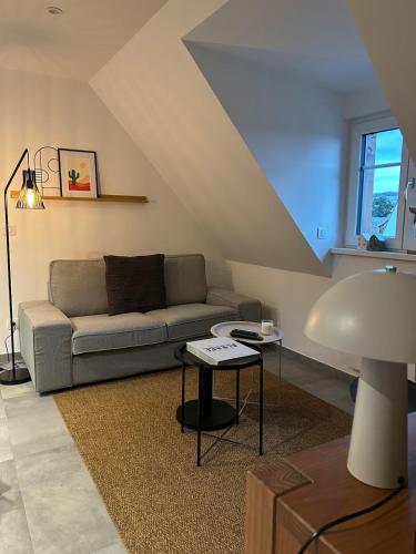 a living room with a couch and a table at Charmant appartement avec vue sur les vignes in Ammerschwihr