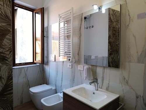 a bathroom with a sink and a toilet and a mirror at MT-Apartments in Bollate