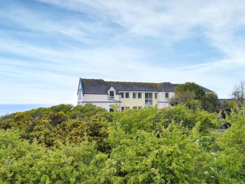 ein Haus auf einem Hügel mit Bäumen in der Unterkunft Spindrift in Coverack