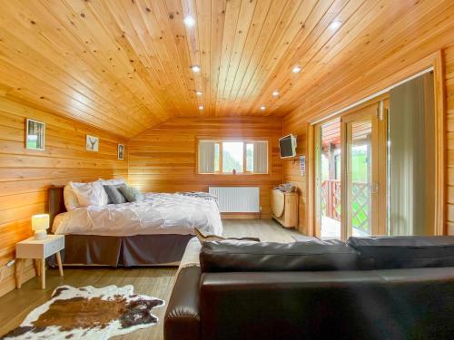 a bedroom with a bed and a couch in a room at Apple-Uk46285 in Camerton