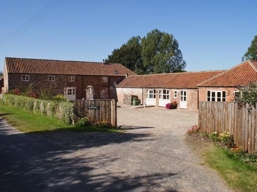 two brick buildings with a fence and a driveway at The Stable - Ijx in Brigham