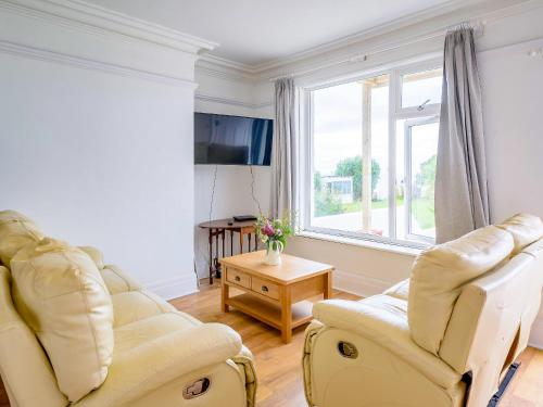 ein Wohnzimmer mit zwei Stühlen und einem Fenster in der Unterkunft On The Beach, East Yardley House - Uk31203 in Downderry