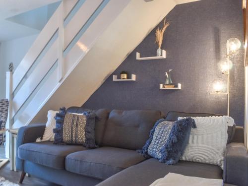 a living room with a couch and a staircase at Seashell House in Burnham on Sea