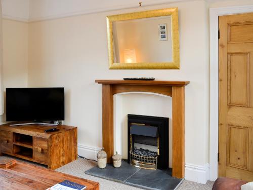 a living room with a fireplace and a mirror at Zonnebloem in Cefn-y-bedd