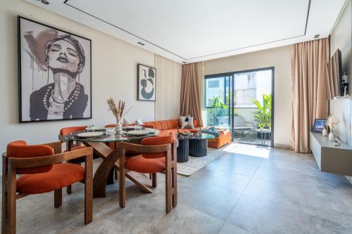 Una sala de estar con una mesa y sillas naranjas. en CFC business, Coworking, gym, self check-in, en Casablanca