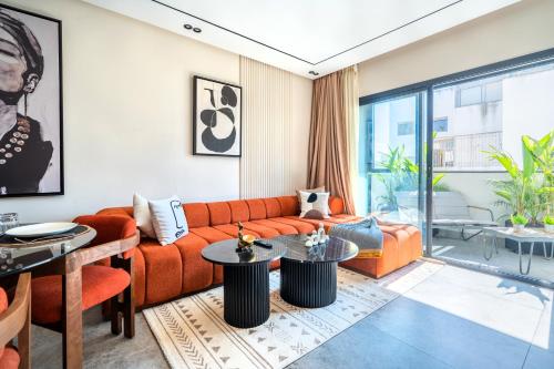 Una sala de estar con un sofá naranja y mesas. en CFC business, Coworking, gym, self check-in, en Casablanca