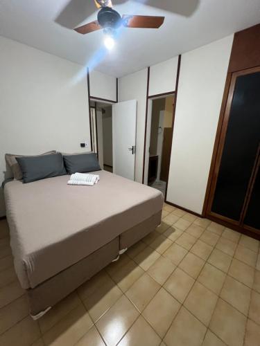 een slaapkamer met een bed en een plafondventilator bij Apartamento 3 suítes perto da Praia do forte e Passagem in Cabo Frio