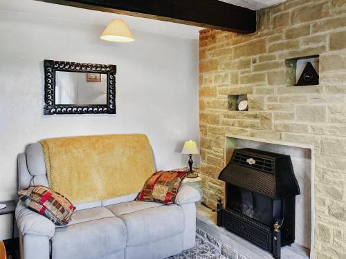 a living room with a couch and a fireplace at Ginny's Cottage in Haworth