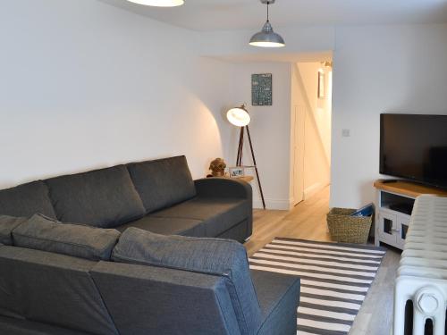 a living room with a couch and a flat screen tv at Rosetta Apartments - Ocean Mist in Newquay