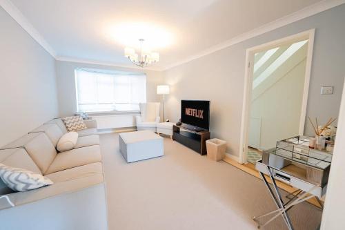 una sala de estar con un sofá y una mesa en 3 Bed House With Free Parking, Garden & Fast Wifi, en Cardiff