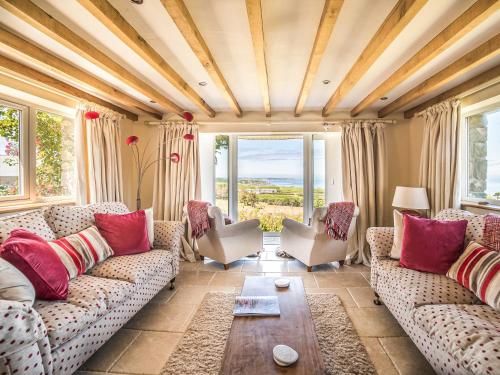 a living room with couches and a table at Tir A Mor in Nefyn