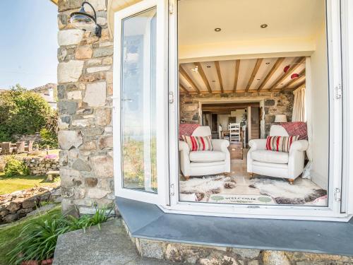 a room with two chairs and a window at Tir A Mor in Nefyn