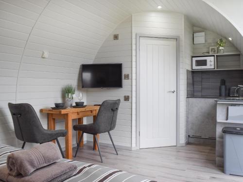 Una habitación con una mesa y sillas y una cocina. en Laurel Pod - Uk47203, en Westhead