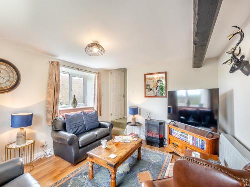 a living room with a couch and a tv at Church View Cottage - Uk45697 in Pickering